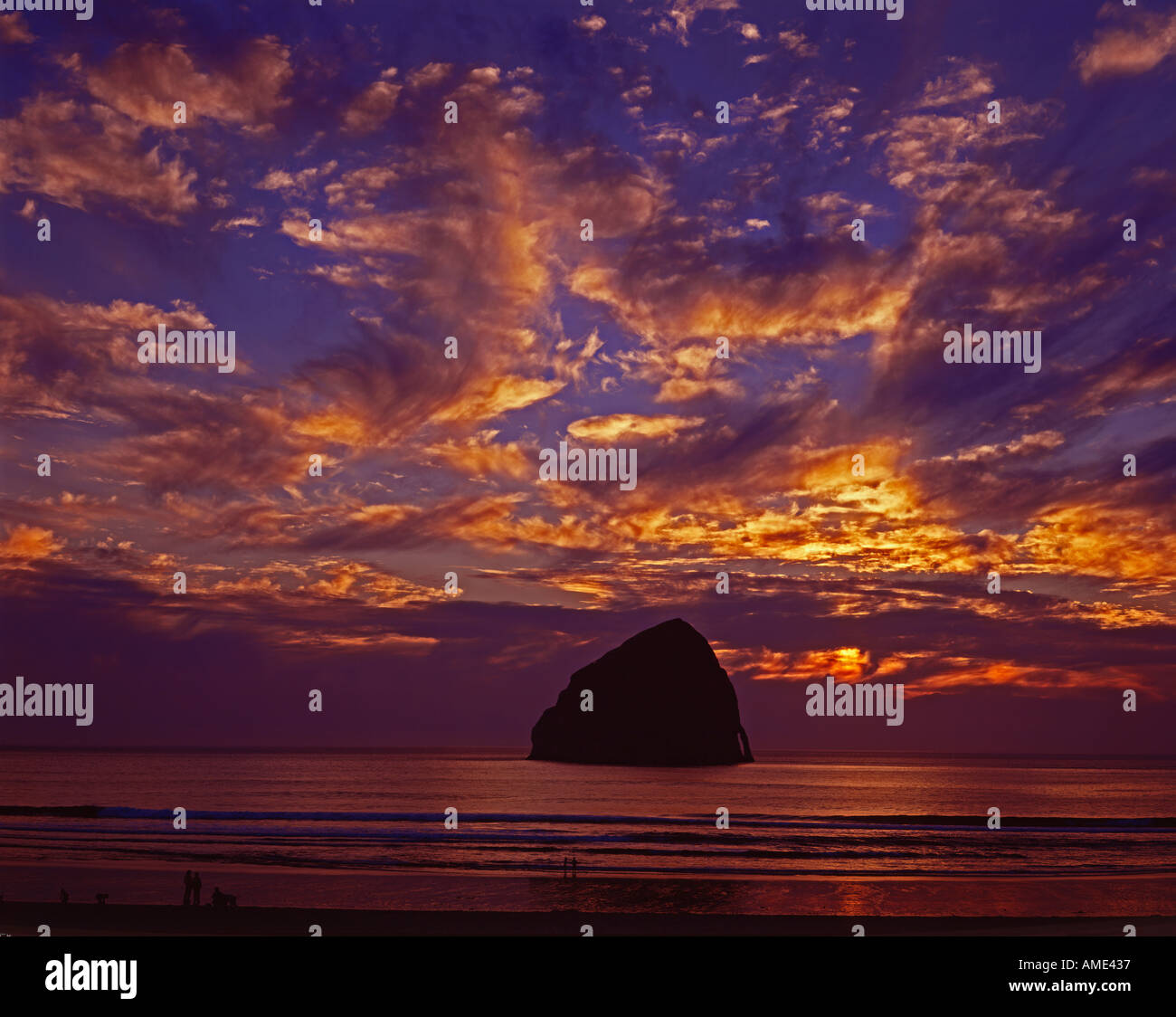 Haystack rock se trouve au large de Cape Kiwanda sur la côte de l'Oregon comme vu au coucher du soleil Banque D'Images