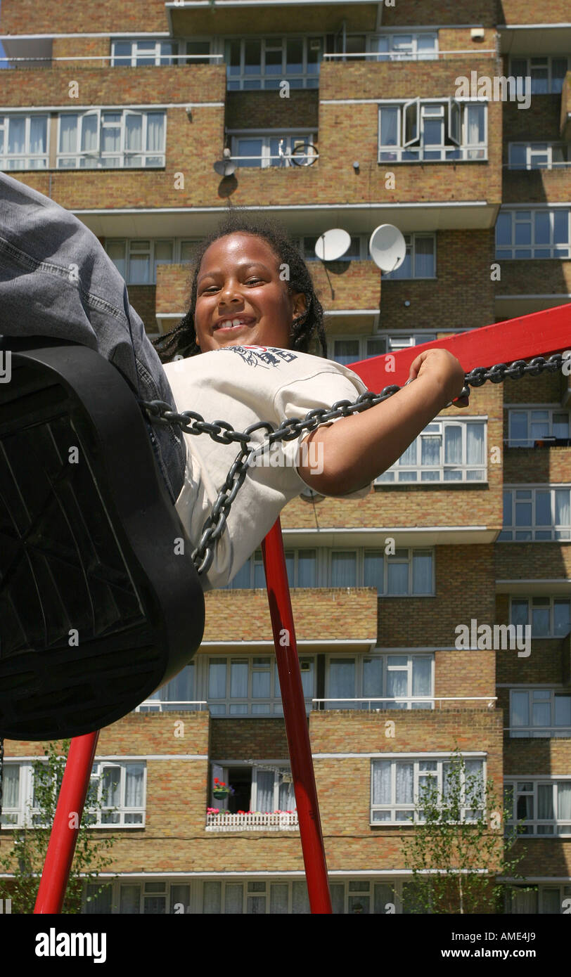 Un garçon de 10 ans jouant sur une balançoire en face d'un ensemble immobilier, Forest Hill, Londres, Royaume-Uni. L'année 2006. Banque D'Images