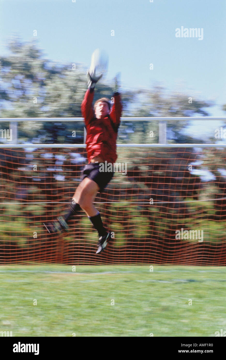 Gardien de but de soccer sautant pour attraper Balle, Ontario, Canada Banque D'Images