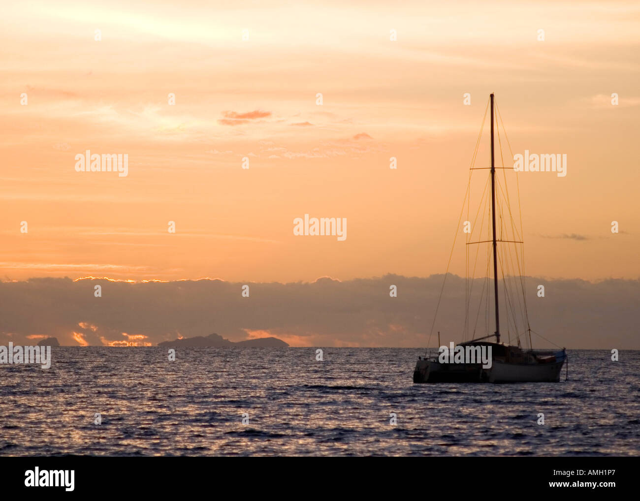 Bateau à voile découpé sur un ciel orange au coucher du soleil, Nadi, Fidji Banque D'Images