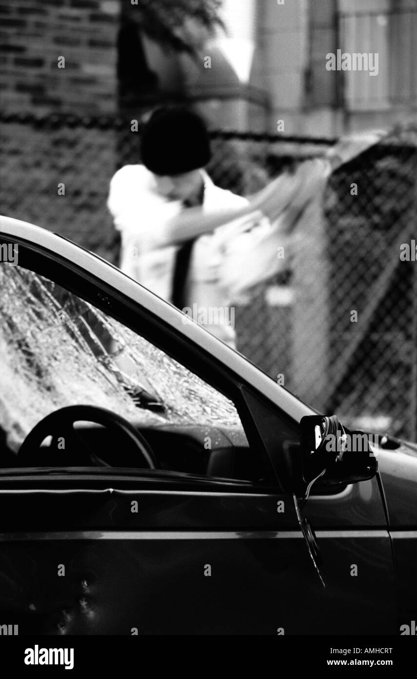 Jeune homme de pare-brise de voiture smashing Banque D'Images