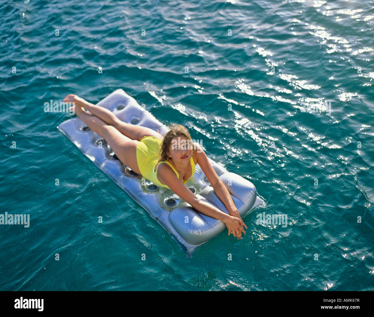 Jeune femme flottant sur le matelas d'air d'argent dans les bains de soleil sur  la mer Photo Stock - Alamy