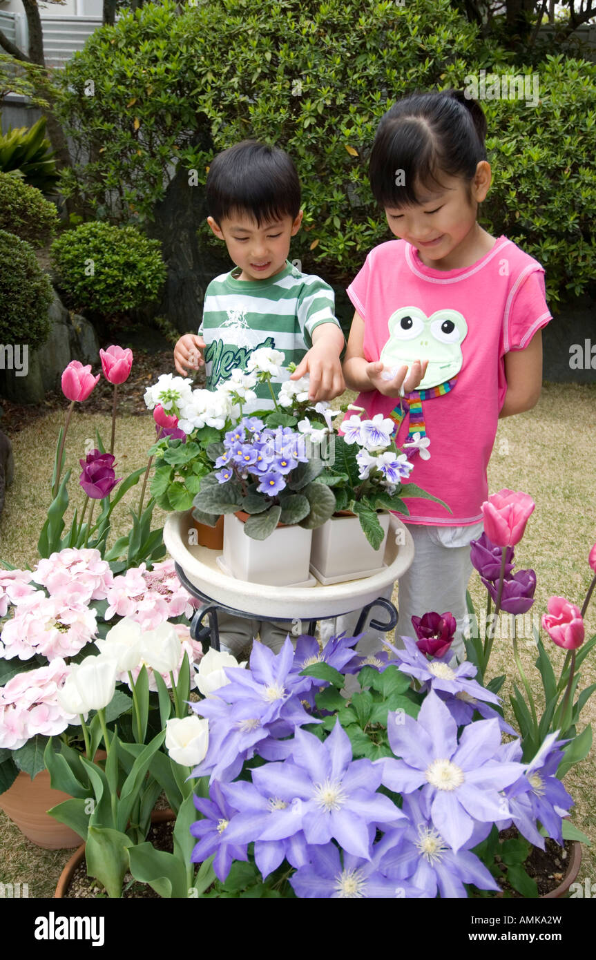 Toucher les enfants dans le jardin de fleurs Banque D'Images