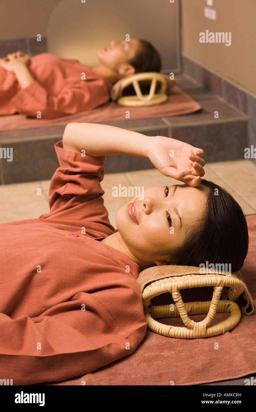 Les jeunes femmes se trouvant à soubassement baignoire Photo Stock - Alamy