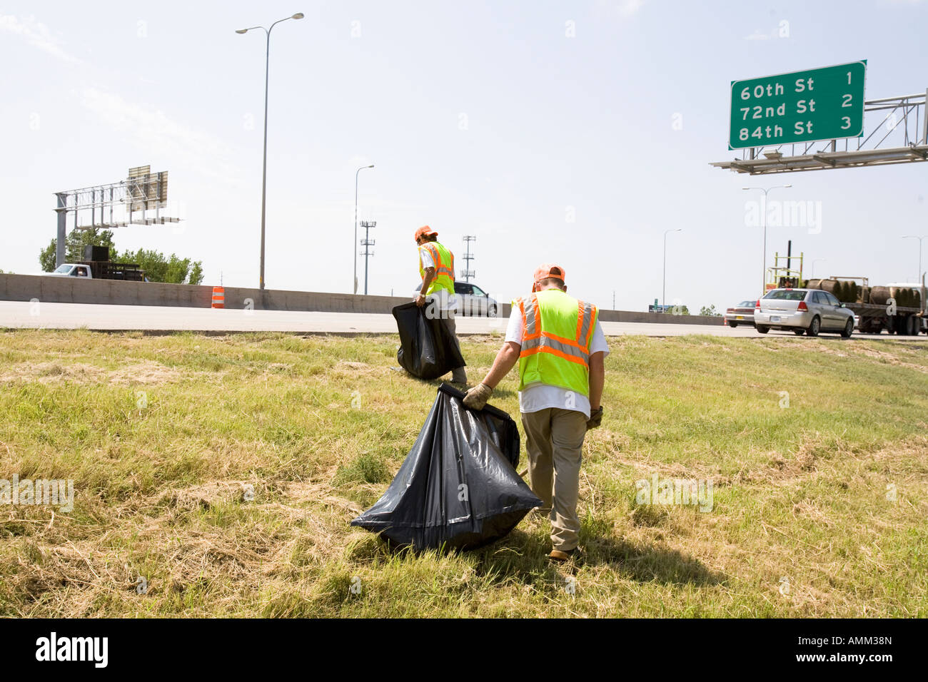 Travailler en collaboration avec les détenus en liberté picking up trash sur le côté de la route. Omaha, Nebraska. Banque D'Images
