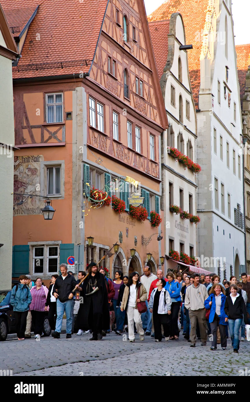 Guide en costume des voyages en groupe dans les rues pavées de Rothenburg ob der Tauber Allemagne Banque D'Images