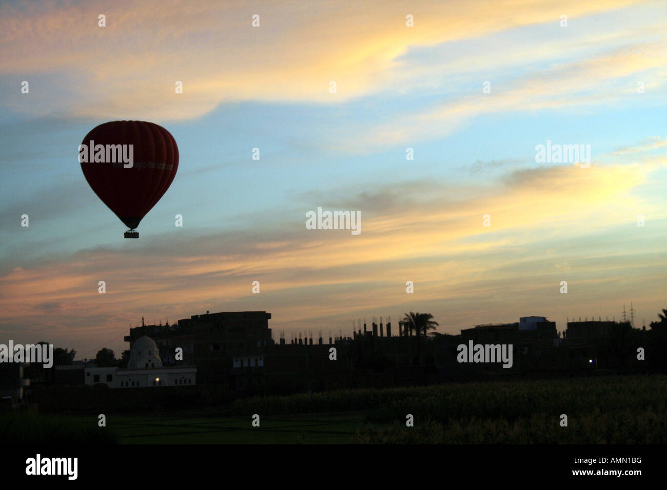Ballon à air chaud qui se profile en face de beau lever [près de Louxor, Egypte, Etats arabes, l'Afrique]. . Banque D'Images