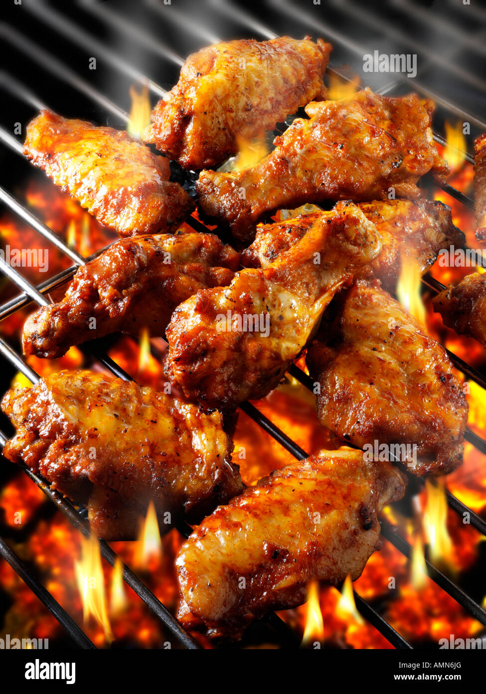 Barbecue avec des charbons ardents et les ailes de poulet épicées Banque D'Images