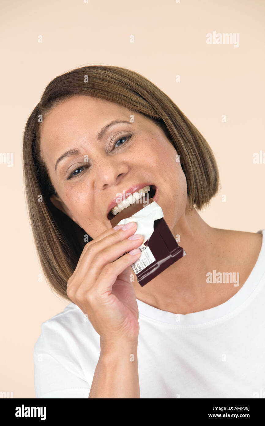 Woman eating chocolate bar Banque D'Images