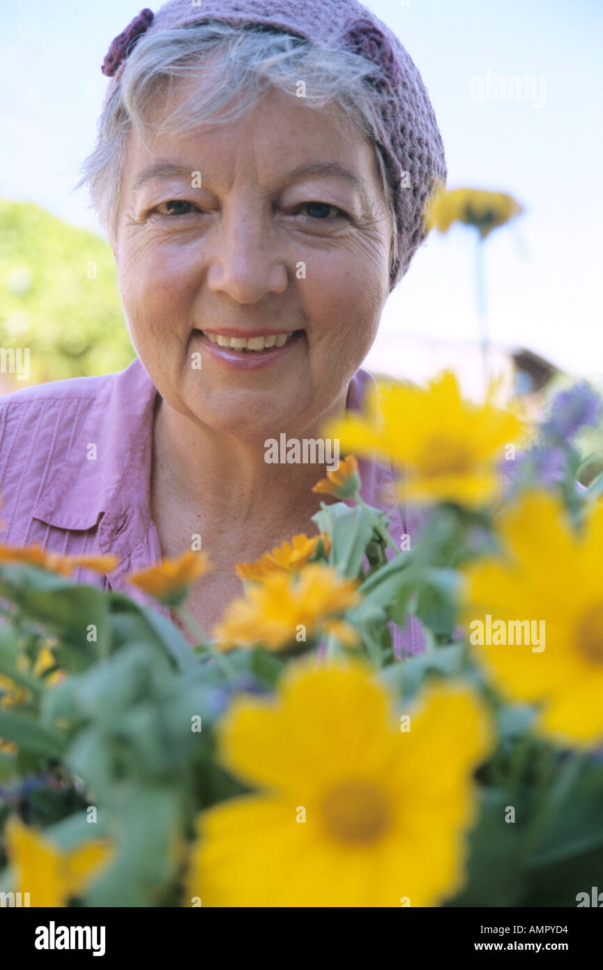 Senior woman in front of flowers, close-up Banque D'Images