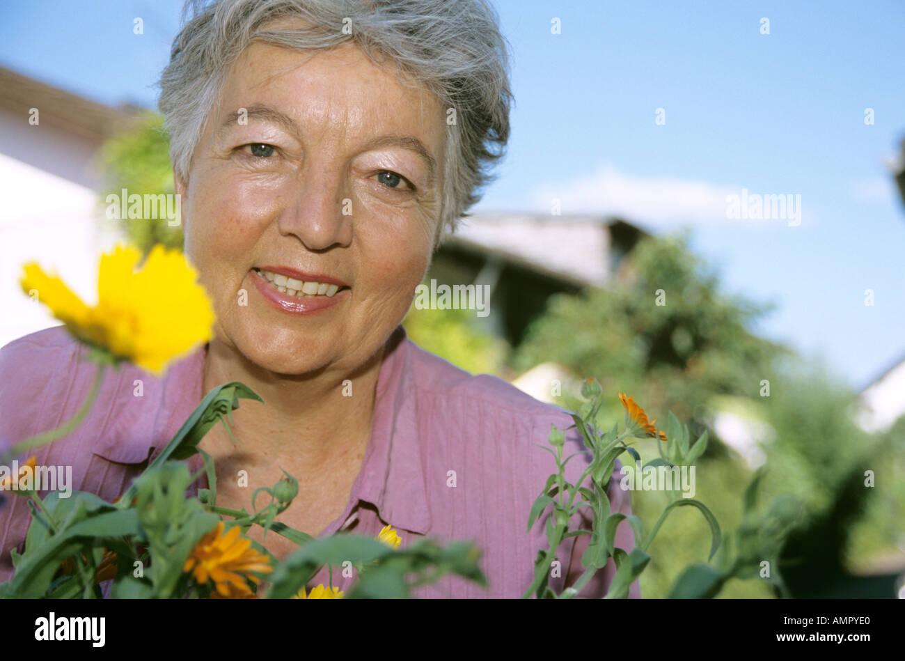 Senior woman in front of flowers, close-up Banque D'Images