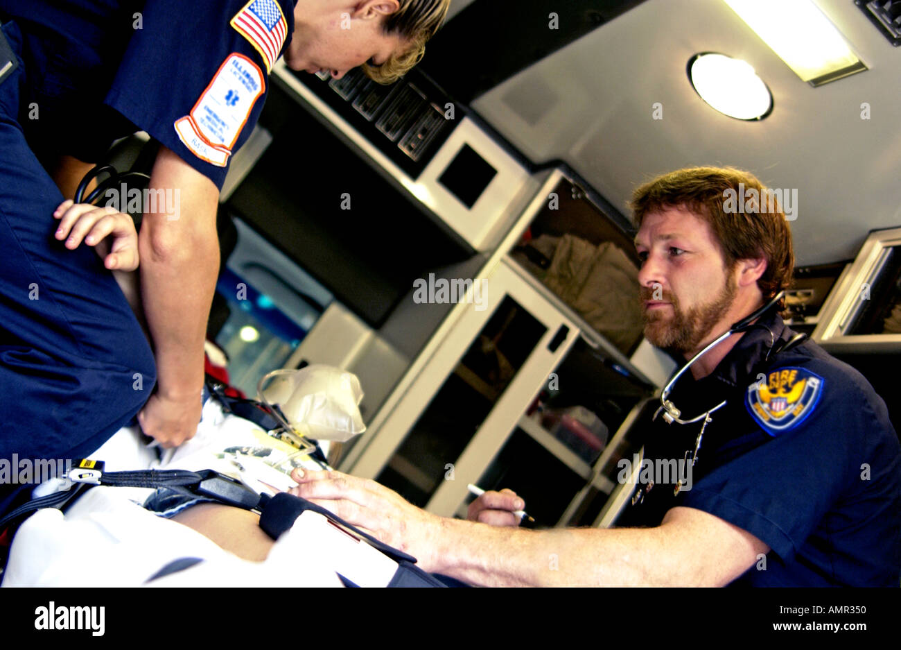 Techniciens avec patient en ambulance Banque D'Images