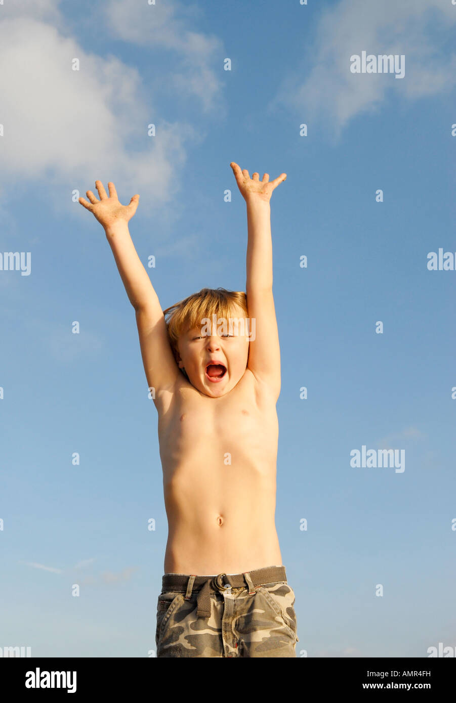 Un garçon de 8 ans saute en l'air lors d'un jeu sur la plage. Banque D'Images