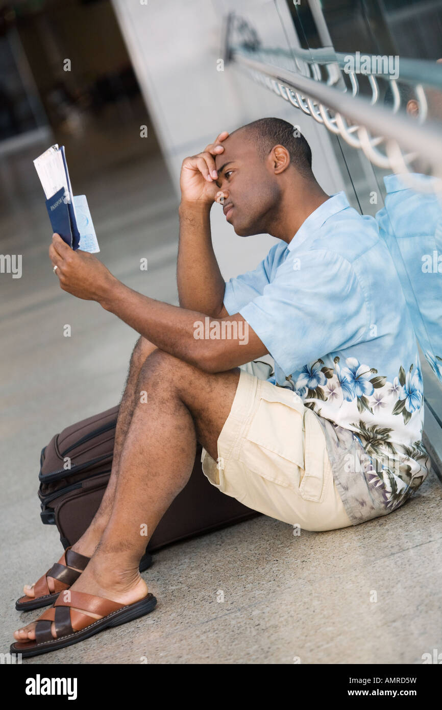 Homme assis à côté de l'Afrique à suitcase Banque D'Images