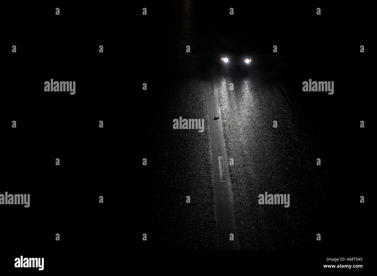Voiture conduite de nuit avec des phares sur Banque D'Images