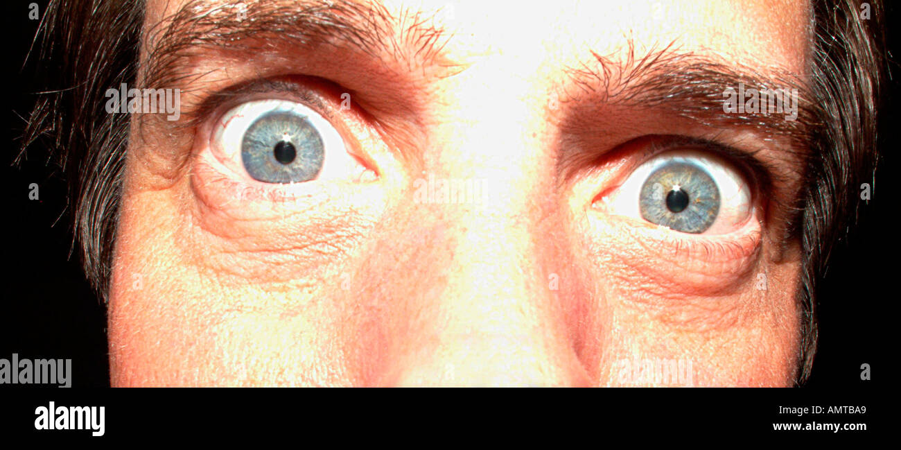 Un homme a les yeux grands ouverts dans une simulation de surprise ou de choc Banque D'Images