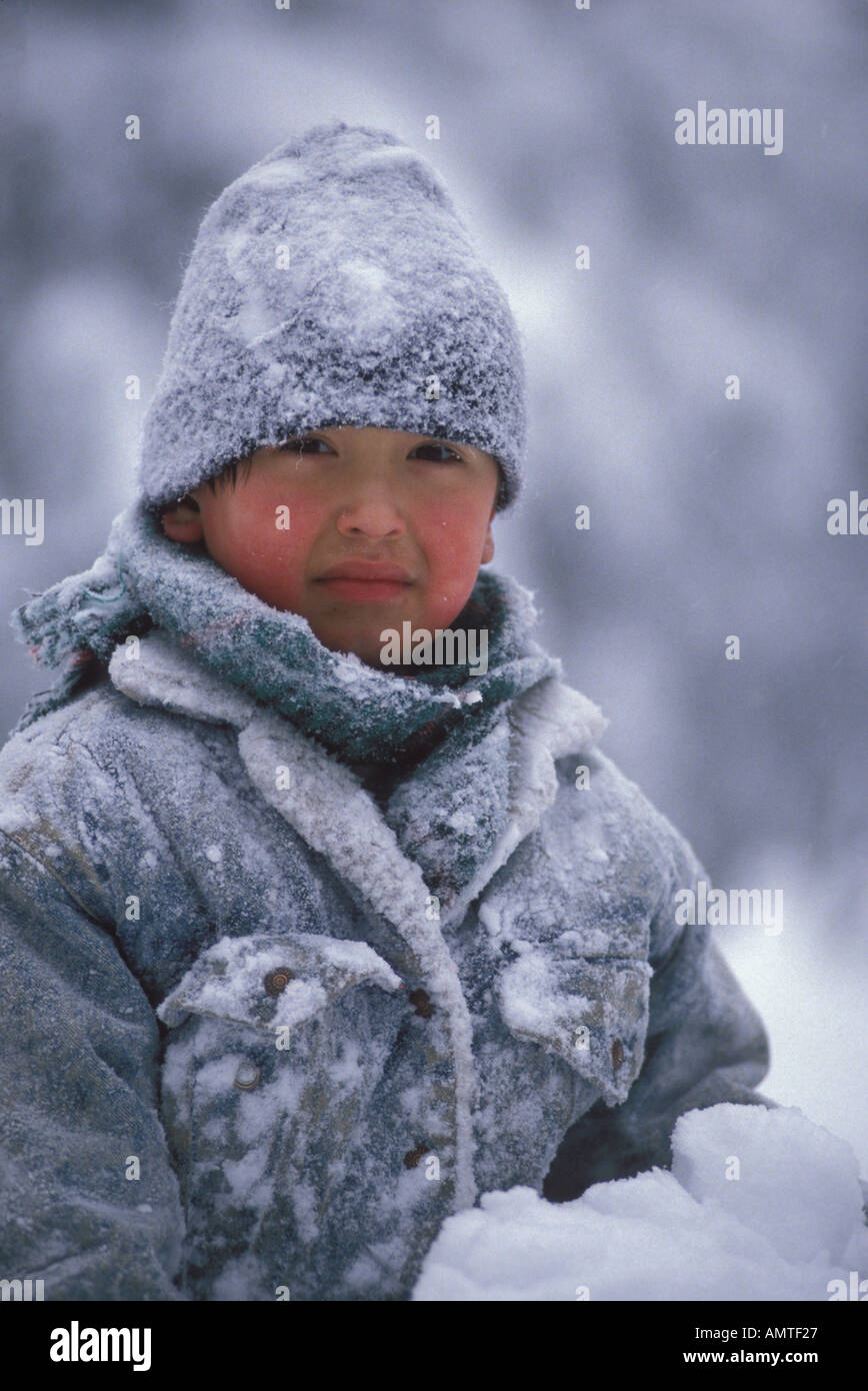 Boy 7 habillé de neige chaud joue dans les joues rouges froid moins 32F en Alaska Banque D'Images