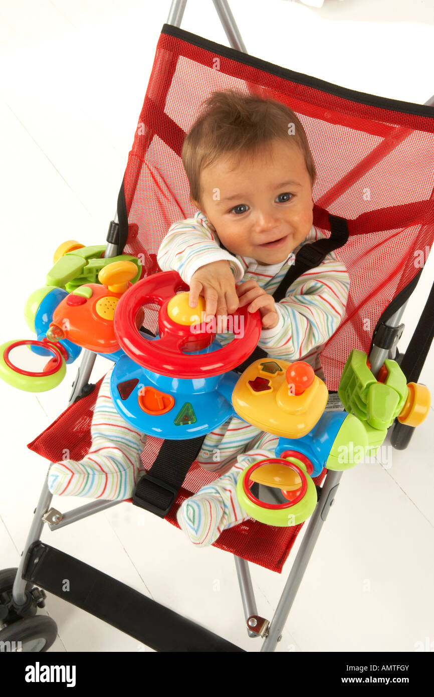 Un Bebe Est Assis Dans Une Poussette Et Joue Avec Un Jouet Volant Photo Stock Alamy