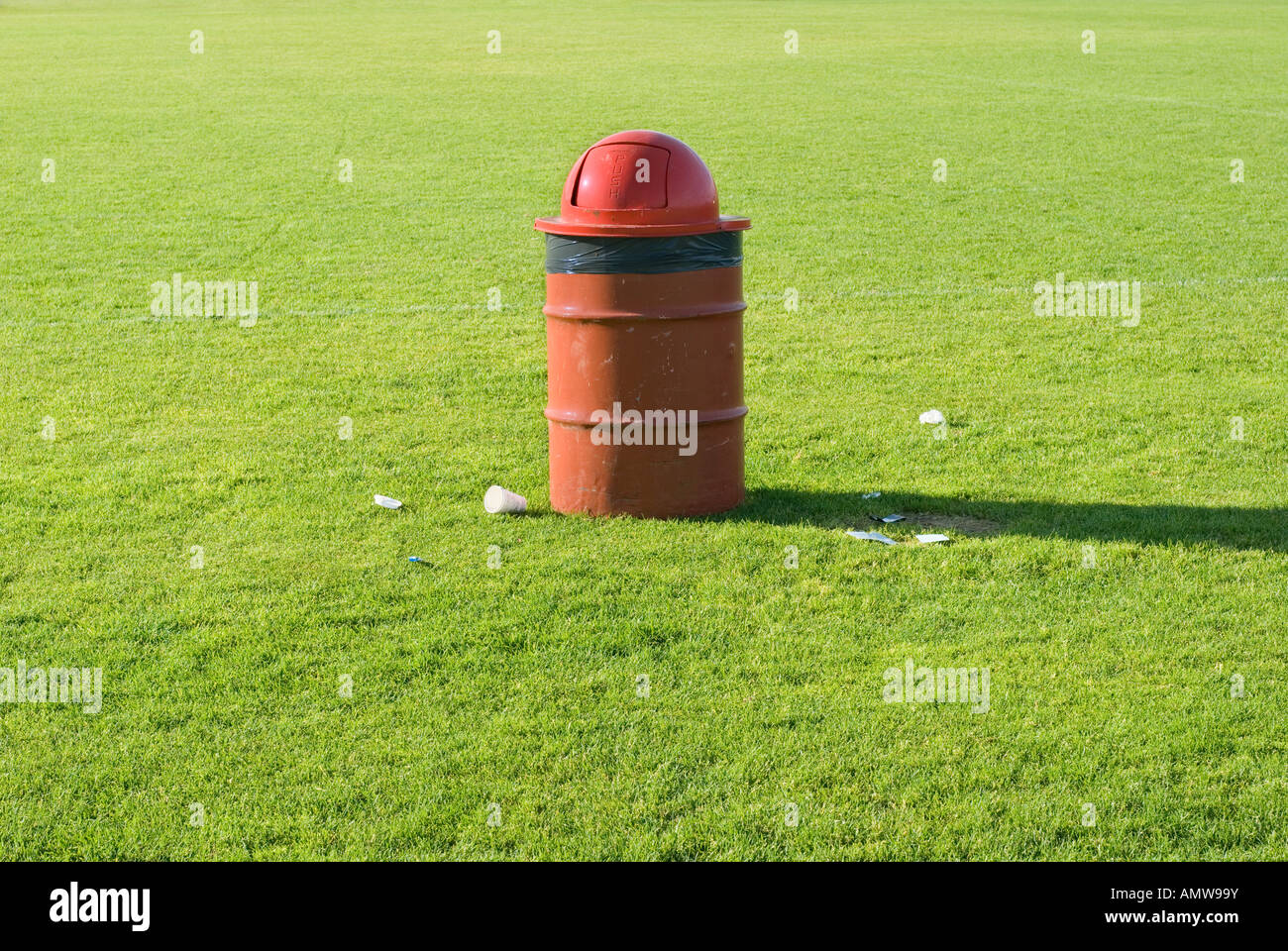 Poubelle rouge sur un terrain de sport avec quelques ordures dispersées qui  n'a pas tout à faire dans le peuvent Photo Stock - Alamy