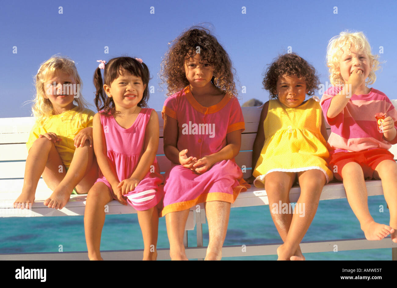 USA, Hawaii. Groupe multiethnique d'enfants assis sur un banc Banque D'Images