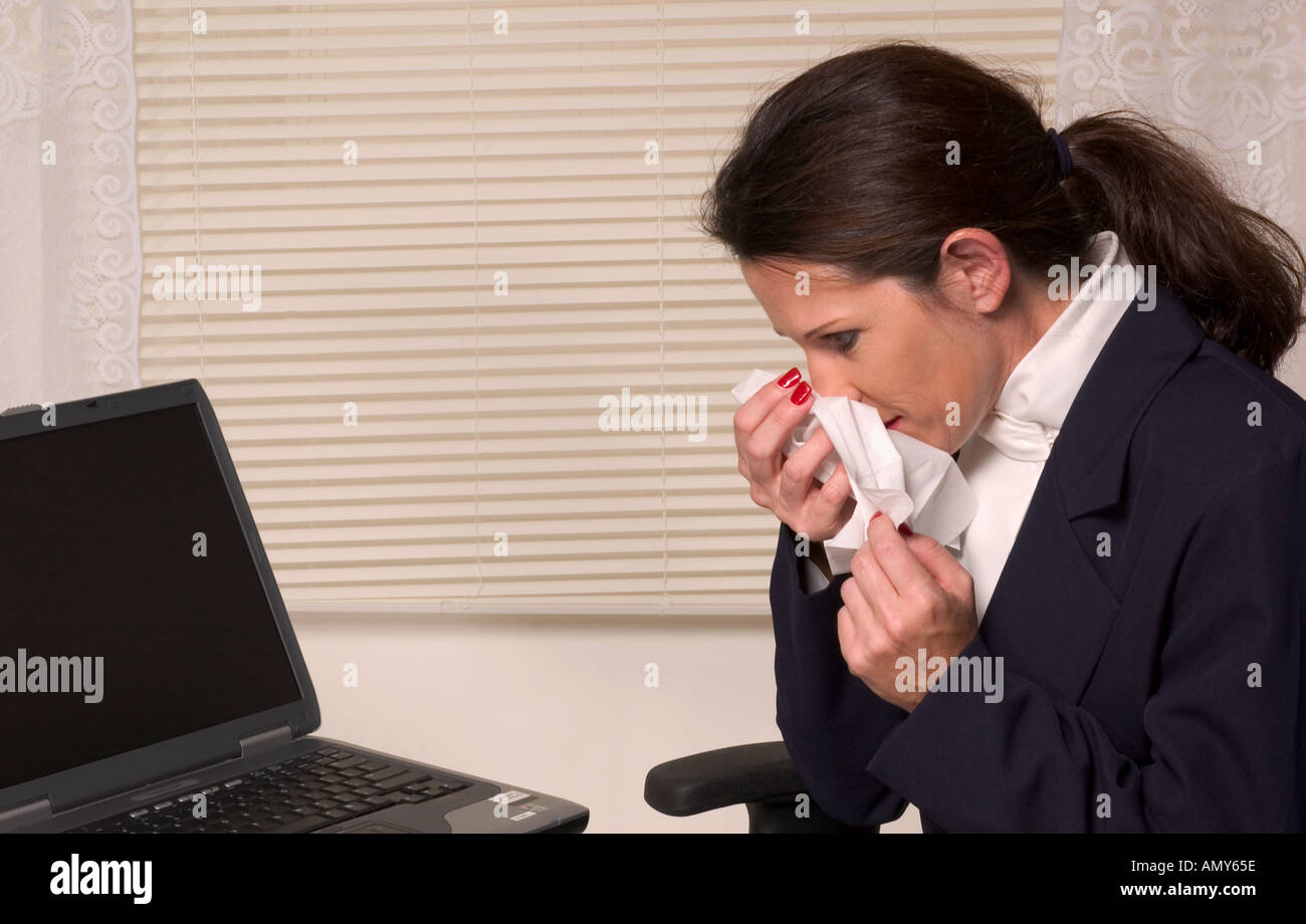 Businesswoman at laptop éternuements nez ou de soufflage. USA Banque D'Images