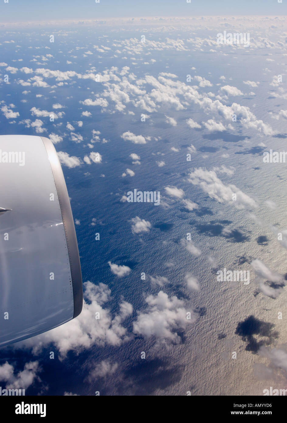 Vue aérienne de l'avion avec moteur à réaction à un niveau élevé au cours de l'océan Pacifique et l'illusion d'optique de nuages blancs touchant presque la mer Banque D'Images