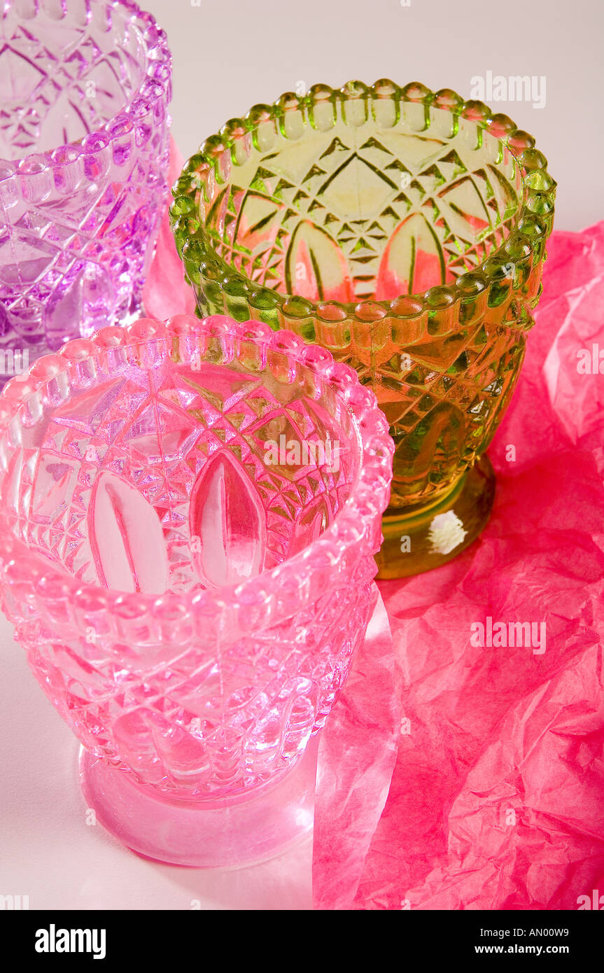 Ensemble de trois multi-verre verres colorés, d'être enveloppé dans du papier de soie rose pour un cadeau. Tourné sur un fond blanc. Banque D'Images