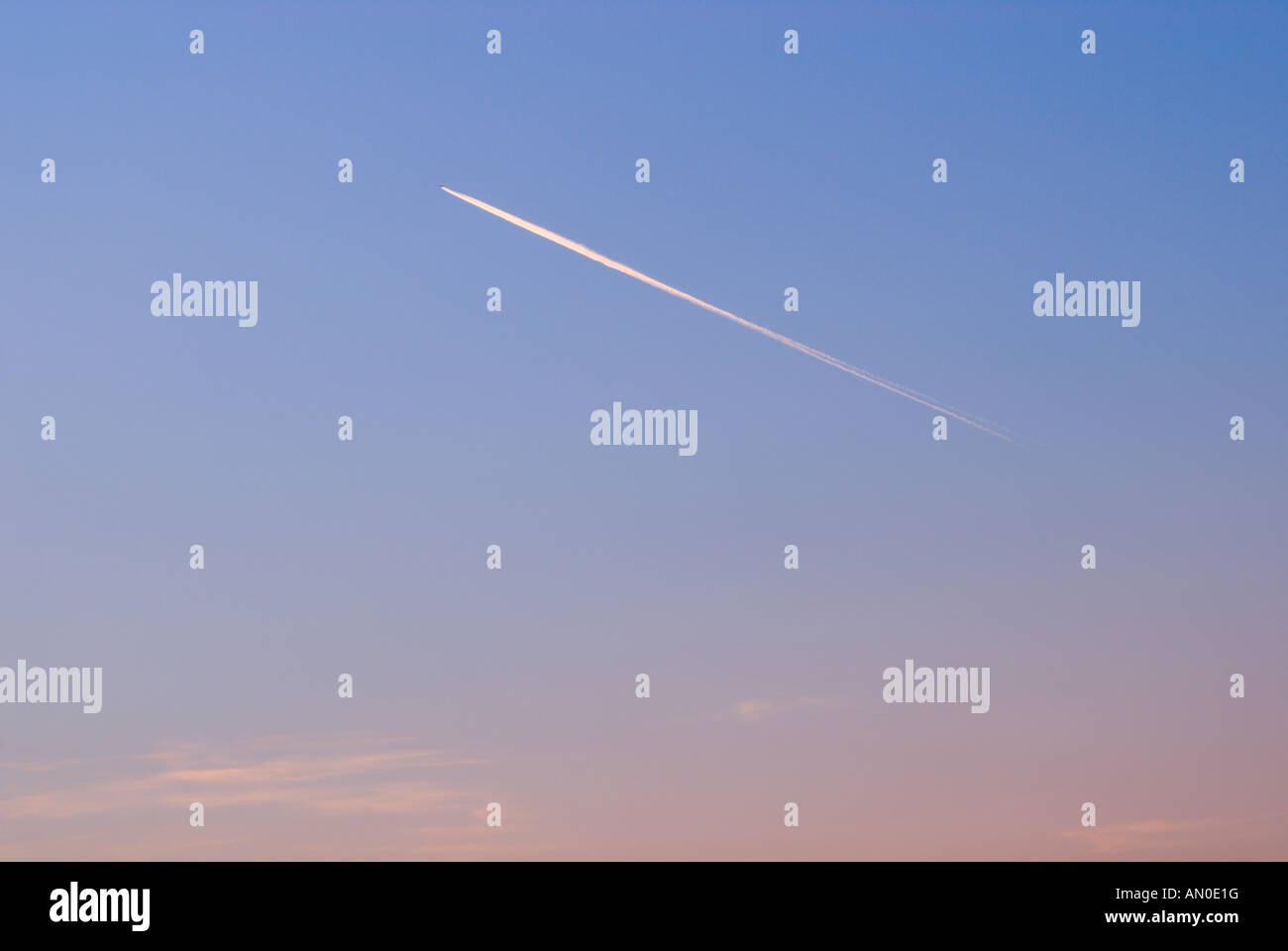 Avions de transport de passagers à travers le ciel de traînées traînées au coucher du soleil Banque D'Images
