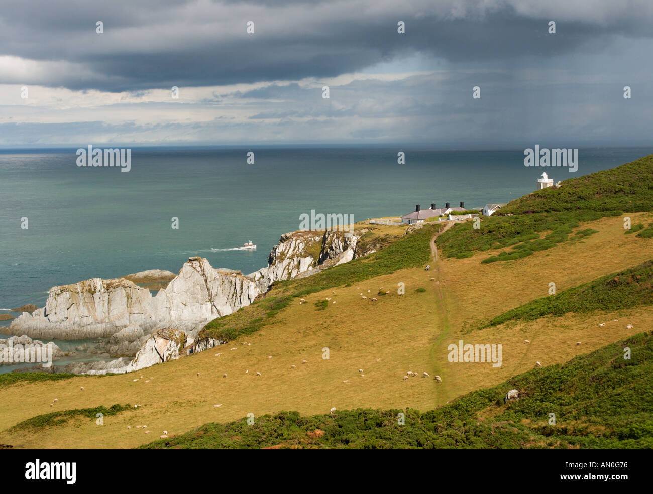 Voir l'est sur la côte nord du Devon à Bull Point Lighthouse avec la pluie qui tombe sur le canal de Bristol au-delà de l'Angleterre Banque D'Images
