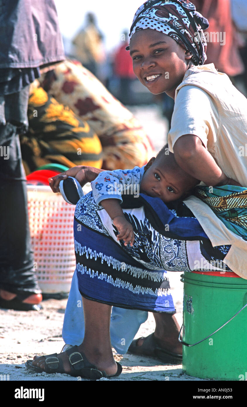 Friendly mère tanzanienne du marché aux poissons tenant son enfant dans ses bras, Dar es Salaam Tanzanie Afrique de l'Est Banque D'Images