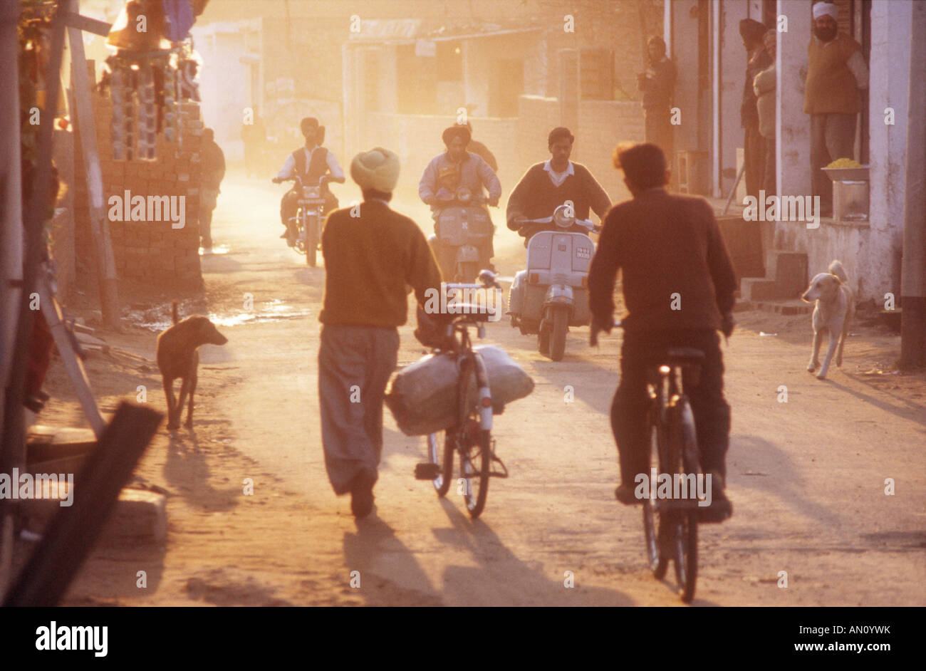 Scène de rue le soir dans Gobindigarh, Punjab Inde avec des vélos, scooters et les chiens. Banque D'Images