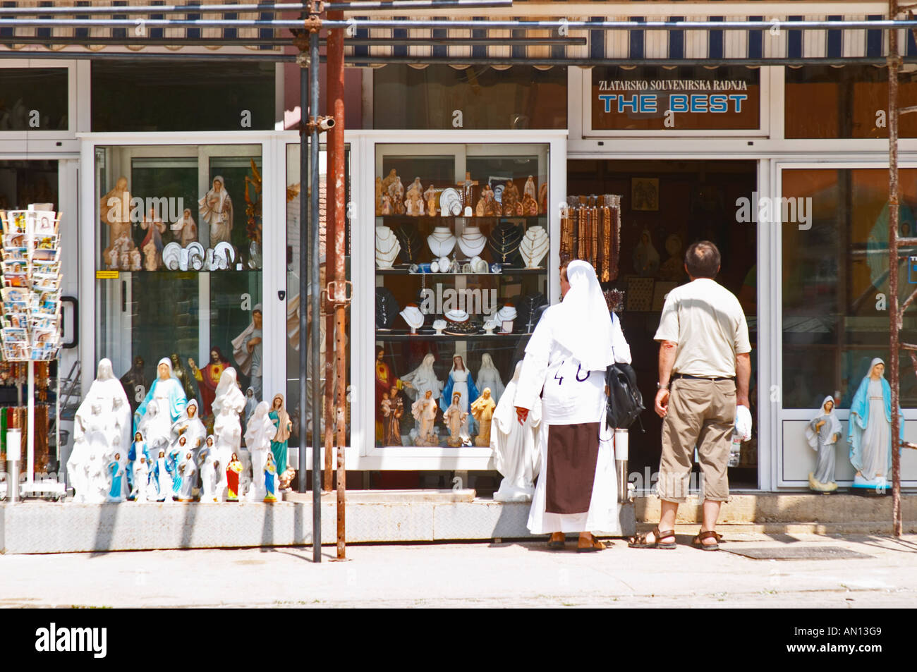 Une boutique de souvenirs pour les pèlerins, appelé 'le meilleur'. Une religieuse en blanc à la recherche de ce pour la vente. Statue de Madonna, chapelet. Medugorje pilgrimage village, près de Mostar. Medjugorje. Russie Bosne i Hercegovine. Bosnie Herzégovine, l'Europe. Banque D'Images