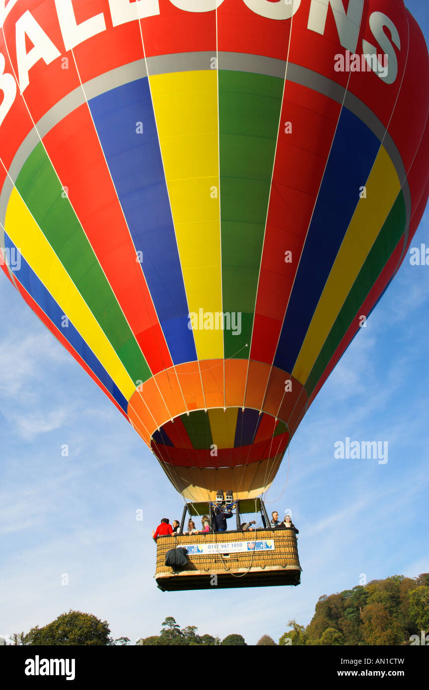 Les gens à l'air chaud ballon panier voler juste au-dessus des arbres Banque D'Images