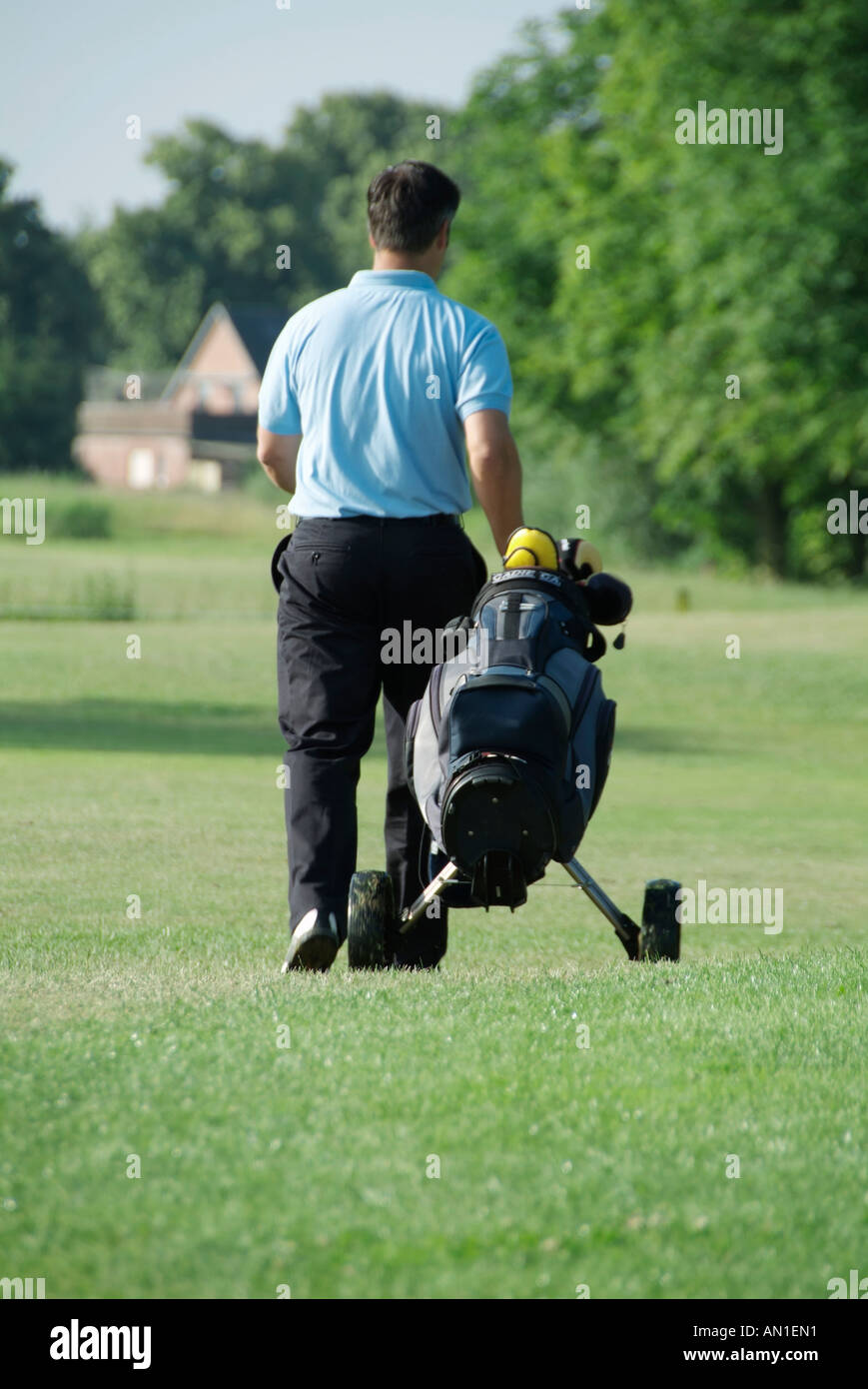 Golf Golf Golf golf, un joueur qui possède son chariot sur fairway Banque D'Images