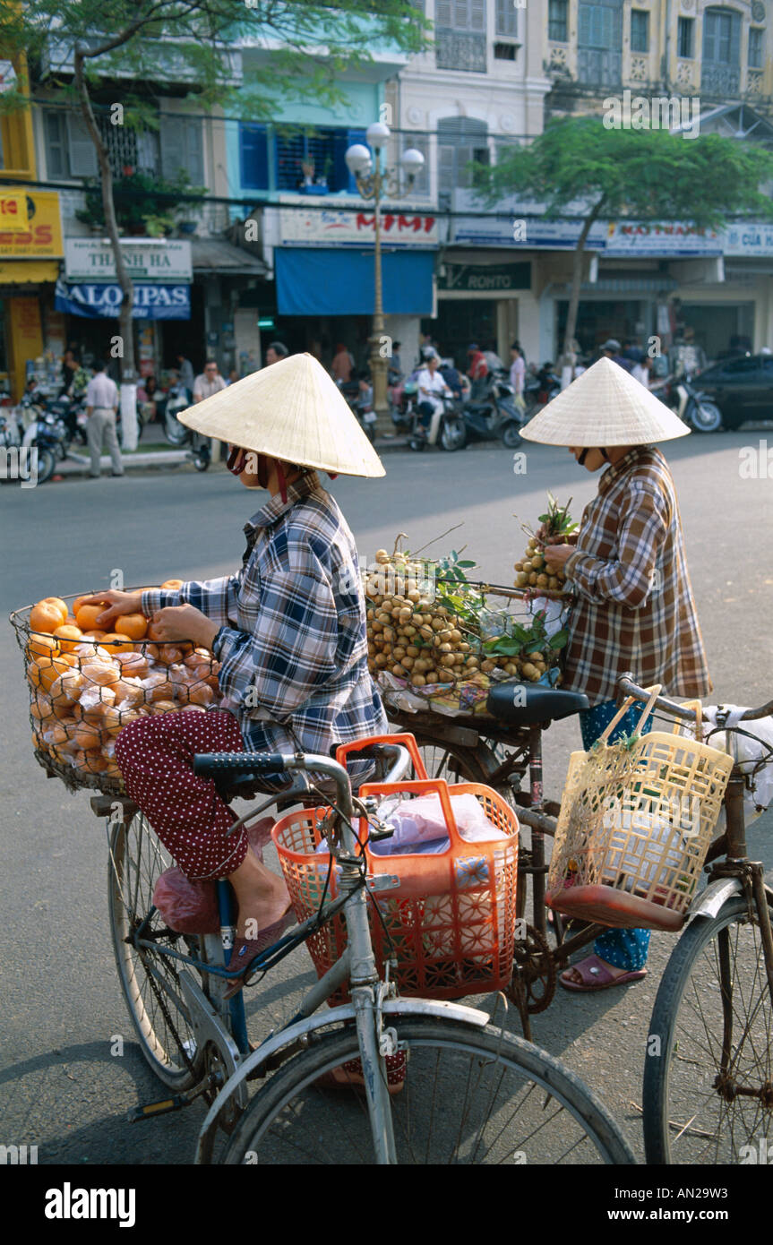 Homme / Femme les vendeurs de rue avec des bicyclettes, Ho Chi Minh Ville (Saigon), Vietnam Banque D'Images
