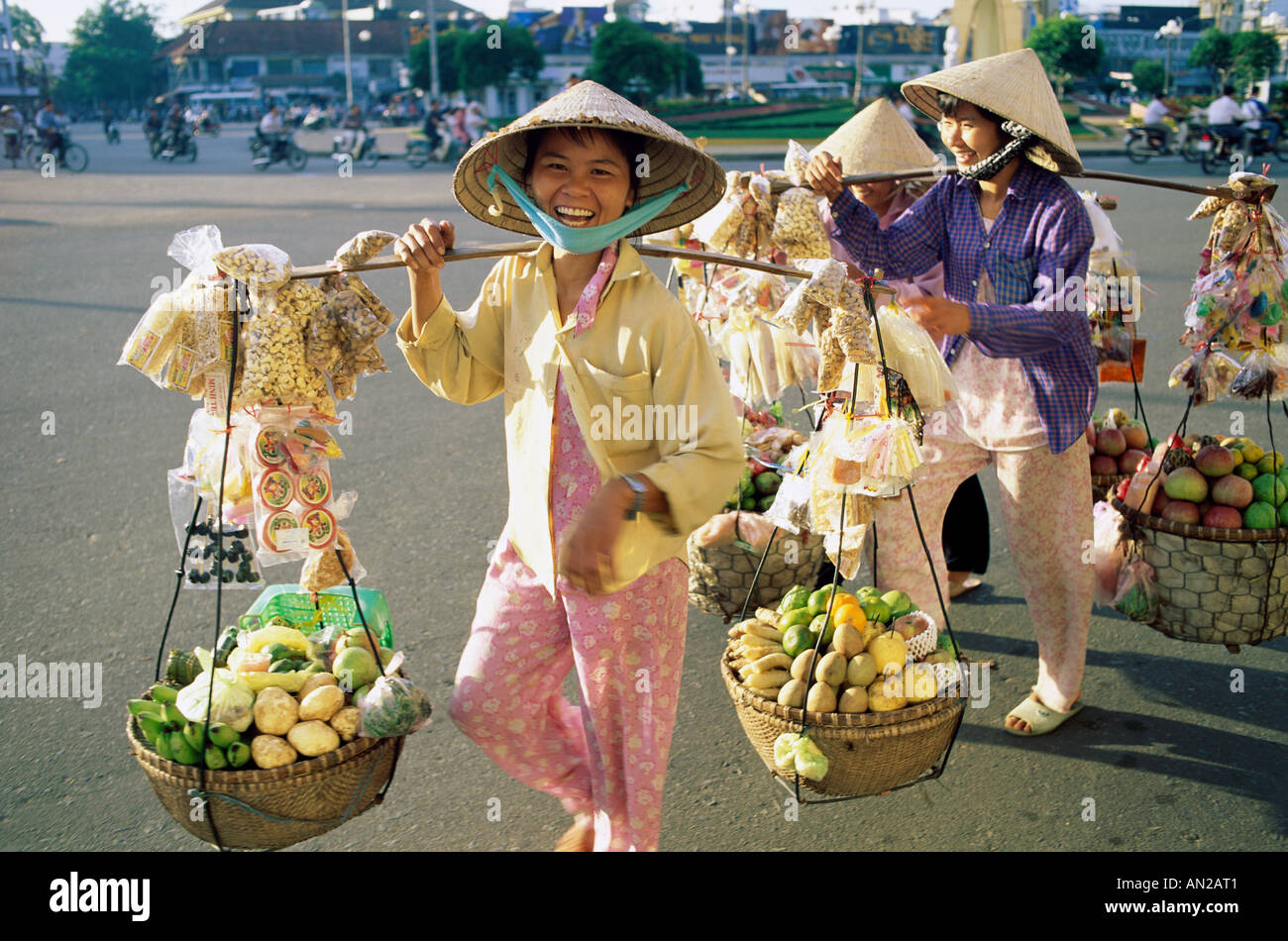 Femme / femmes vendeuses transportant des produits au marché, Ho Chi Minh Ville (Saigon), Vietnam Banque D'Images