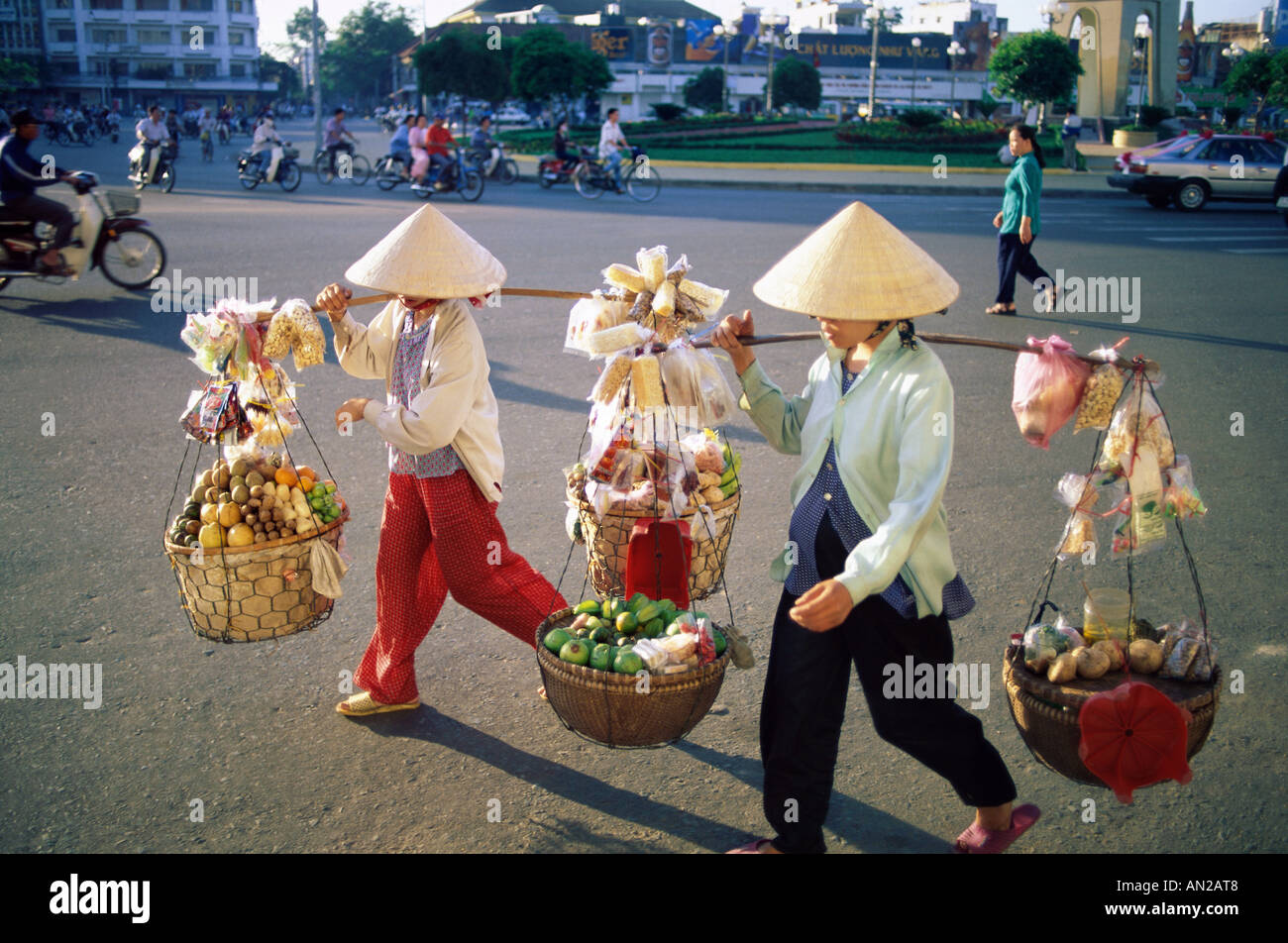 Femme / femmes vendeuses transportant des produits au marché, Ho Chi Minh Ville (Saigon), Vietnam Banque D'Images