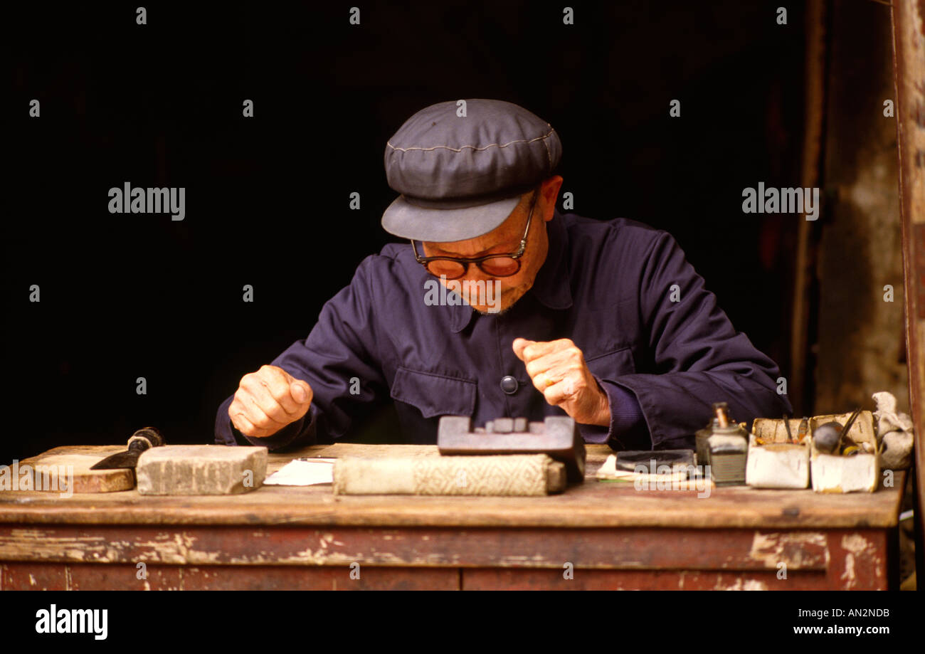 Un scribe travaillant dans le seuil de sa maison. La Chine, Yangshou Banque D'Images