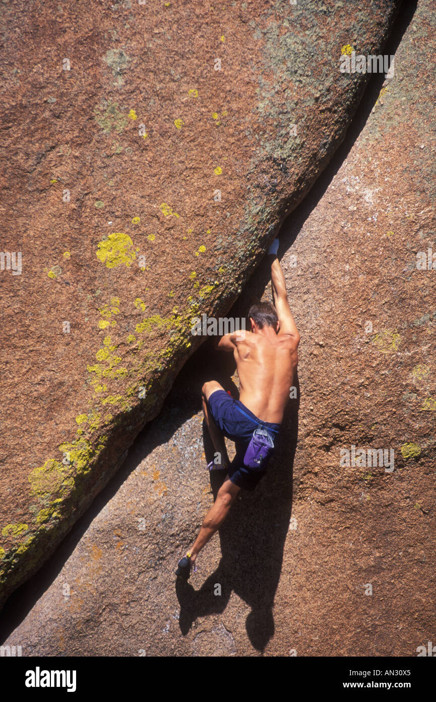 Rock climber bouldering une grante crack Banque D'Images