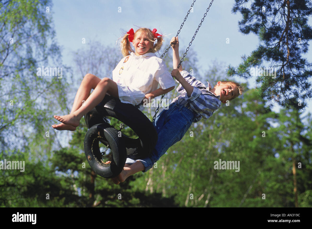 Garçon et fille partager swing sur journée d'été en Suède Banque D'Images