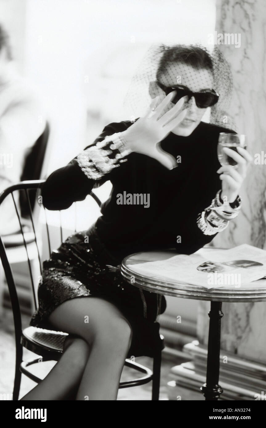 Image en noir et blanc chic de jeune femme ayant un verre de vin