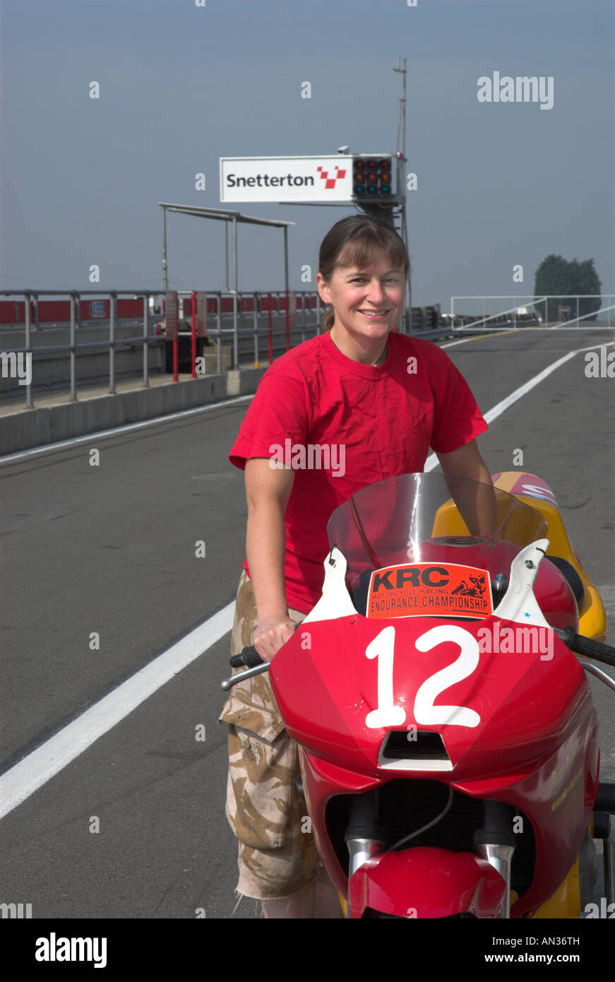 Moto femme Racer et vélo dans la voie des stands de Snetterton Banque D'Images