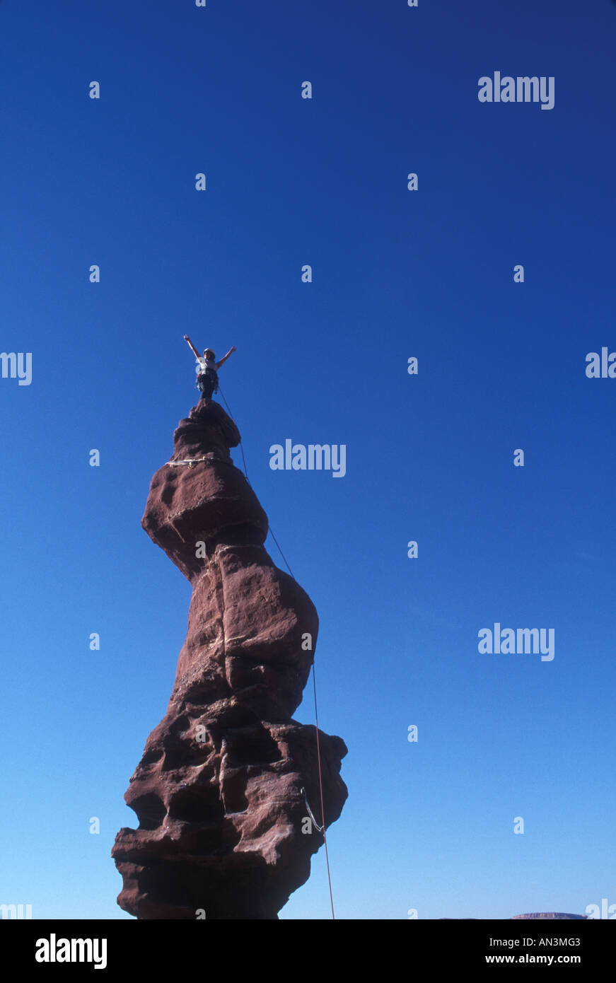 Rock climber debout sur le sommet d'un rocher pinnacle Banque D'Images