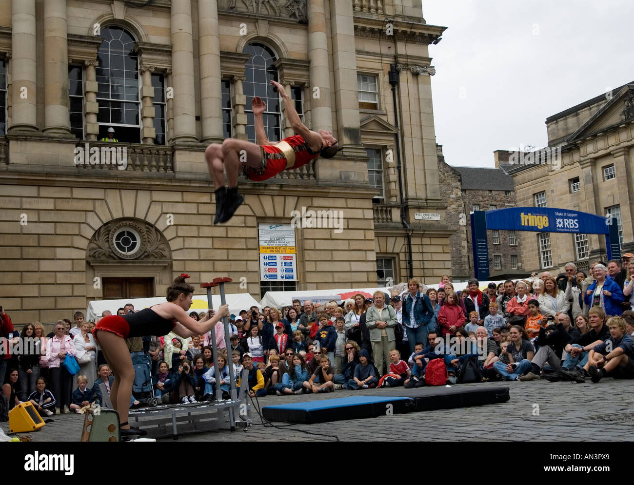 Artiste de rue faisant un saut périlleux arrière mortel dans le Royal Mile d'Édimbourg pendant le Festival Fringe Banque D'Images