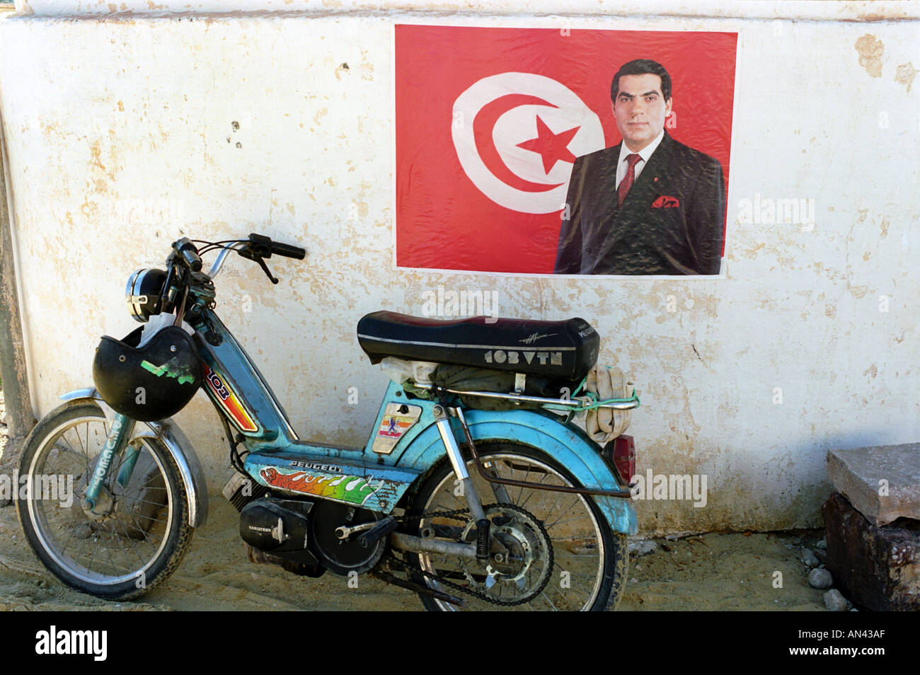 Une affiche pour le président tunisien Ben Ali à côté de l'un des nombreux cyclomoteurs utilisés dans le pays Banque D'Images