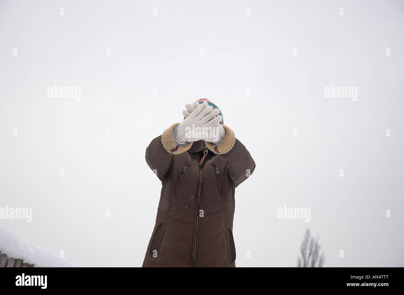 Woman holding up gants en face de visage Banque D'Images