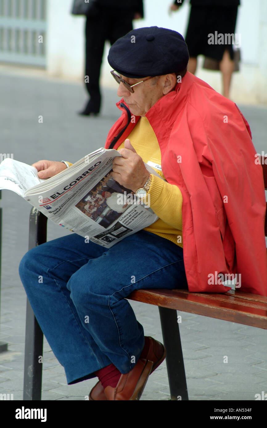 La lecture de l'homme espagnol journal El Correo portant une casquette et  assis sur un siège dans la rue Photo Stock - Alamy