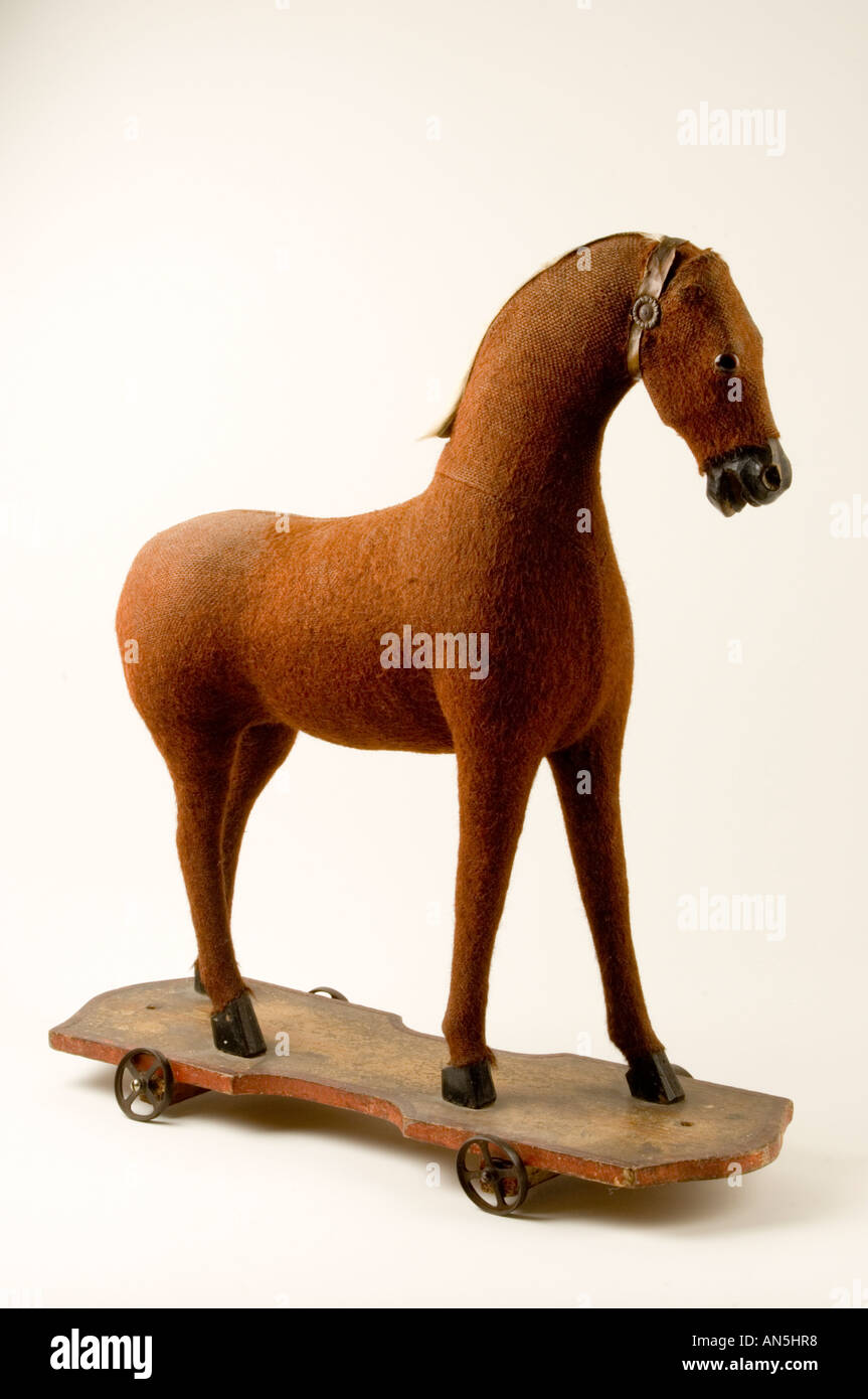 Vieux jouet enfant cheval peluche sur roues sur fond blanc en studio de photographie Banque D'Images