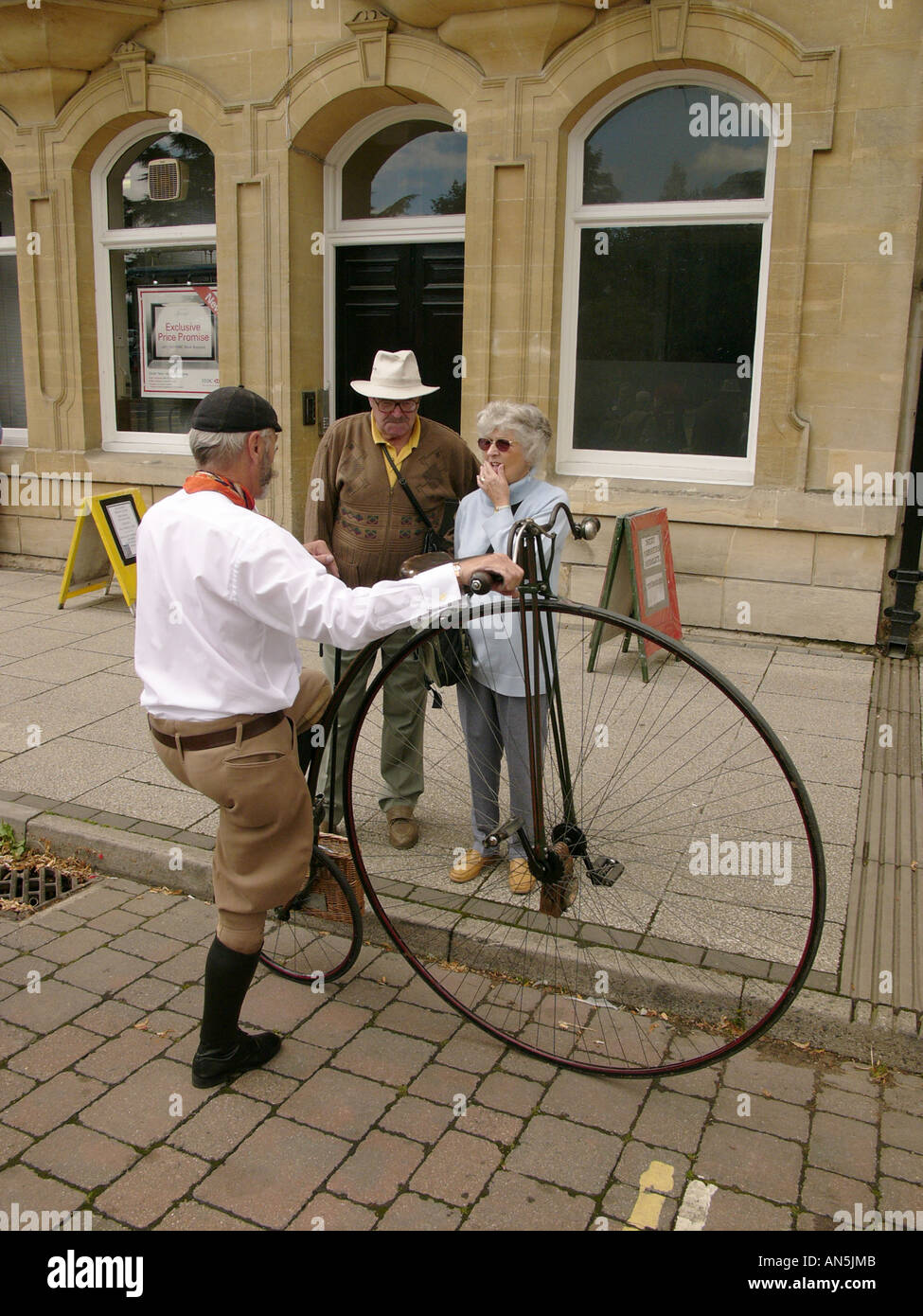 Victorienne Llandrindod Wells Powys Pays de Galles festival - homme avec Penny Farthing bike parler à un couple de touristes Banque D'Images