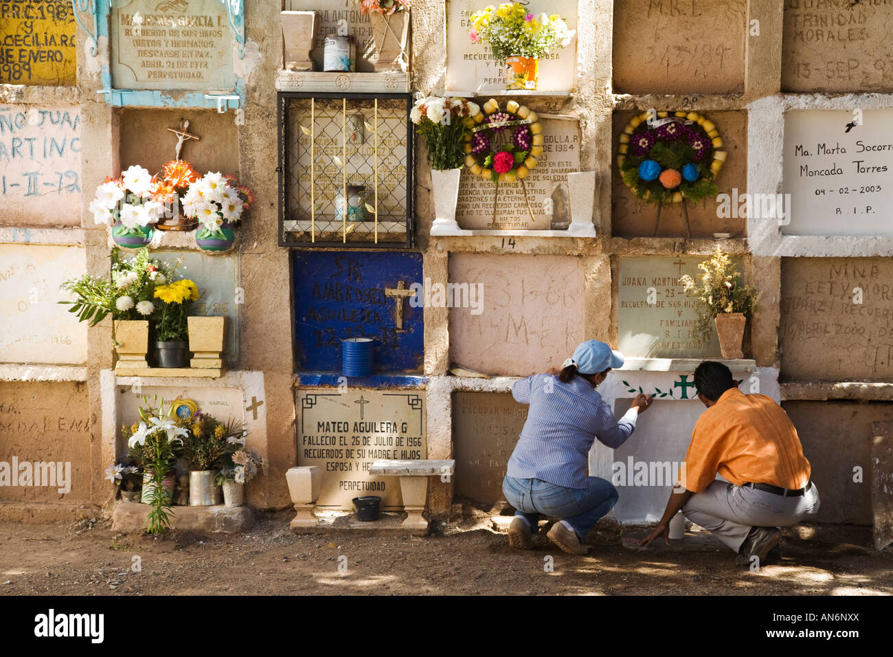 Mexique Guanajuato l'homme et de la femme en peinture crypte cimetière le Jour des Morts Les rangées de fleurs célébration cryptes on ledge Banque D'Images